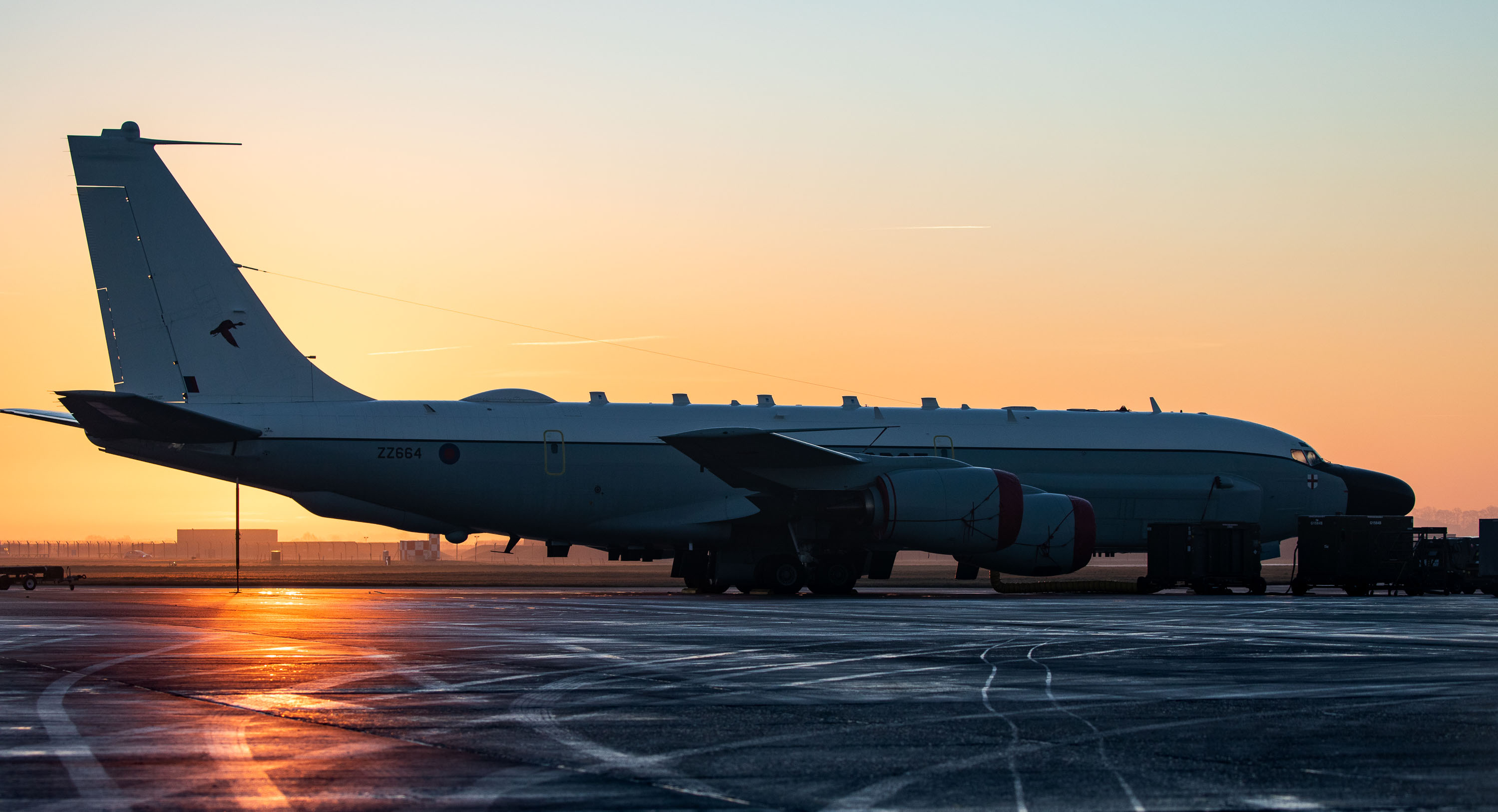 RC-135W Rivet Joint on the airfield during sunset.
